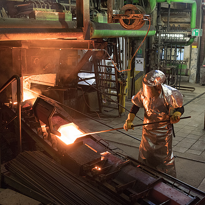 Photo: Aurubis: Worker with long metal rod in hand